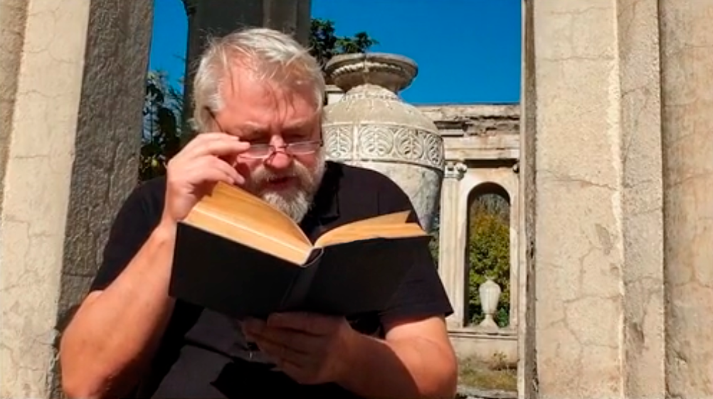 Aleksei Meniailov reads out a fragment of Nemirovich-Danchenko's book at the ancient ruins in the vicinity of Gori. A frame from the video seminar "Mitra comes out of a stone and kills a bull"