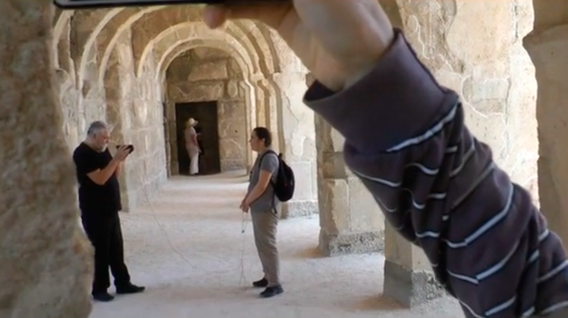 Aleksei Meniailov records an interview with his wife Slatana Meniailova at the ancient theater of Aspendos. A frame from the video seminar "Secrets of Dionysus"