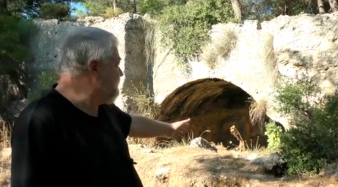 Aleksei Meniailov on the background of the ancient Mithraeum in the vicinity of the city of Perga