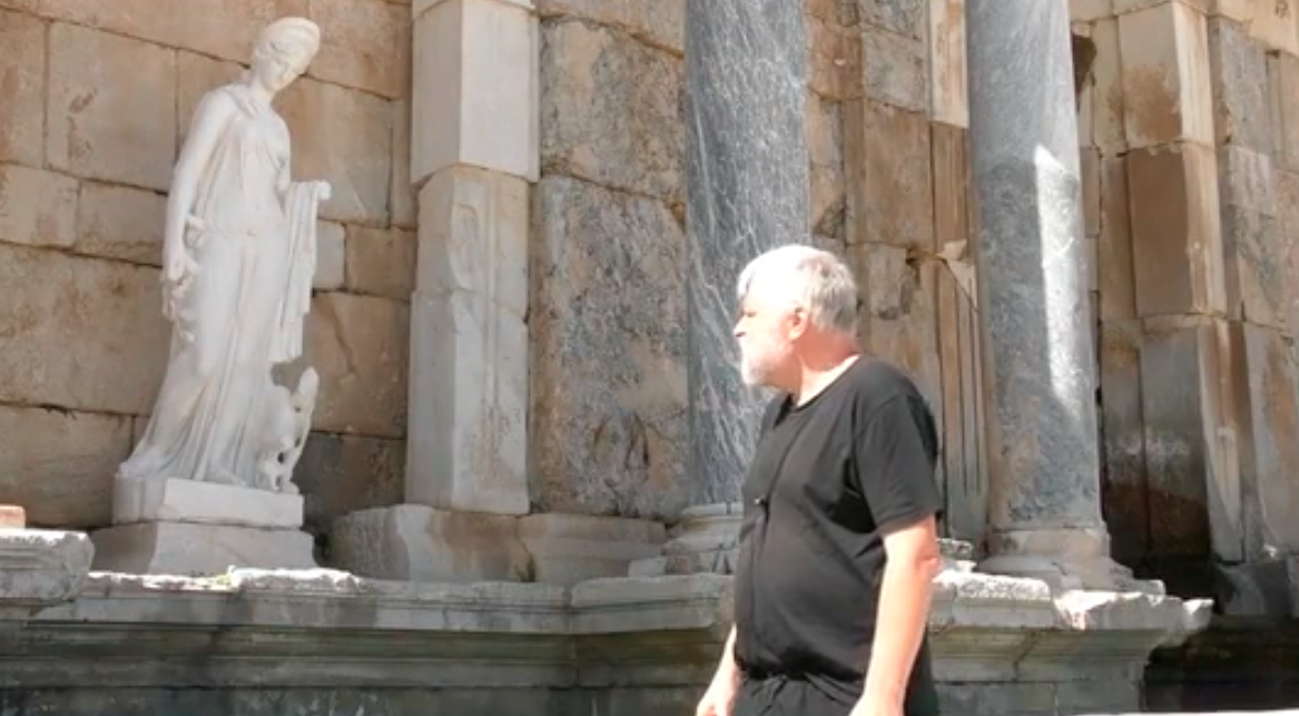 Aleksei Meniailov at the sculpture in the nymphaeum of the ancient city of Sagalassos. A frame from a video lecture about the ancient nymphaeum