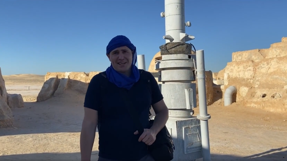 Reader Aleksei Meniailov records an interview against the backdrop of the scenery for the movie "Star Wars" in the Sahara Desert